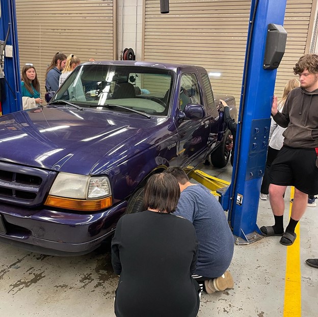 Students learning how to change a tire at Lumpkin County High School.