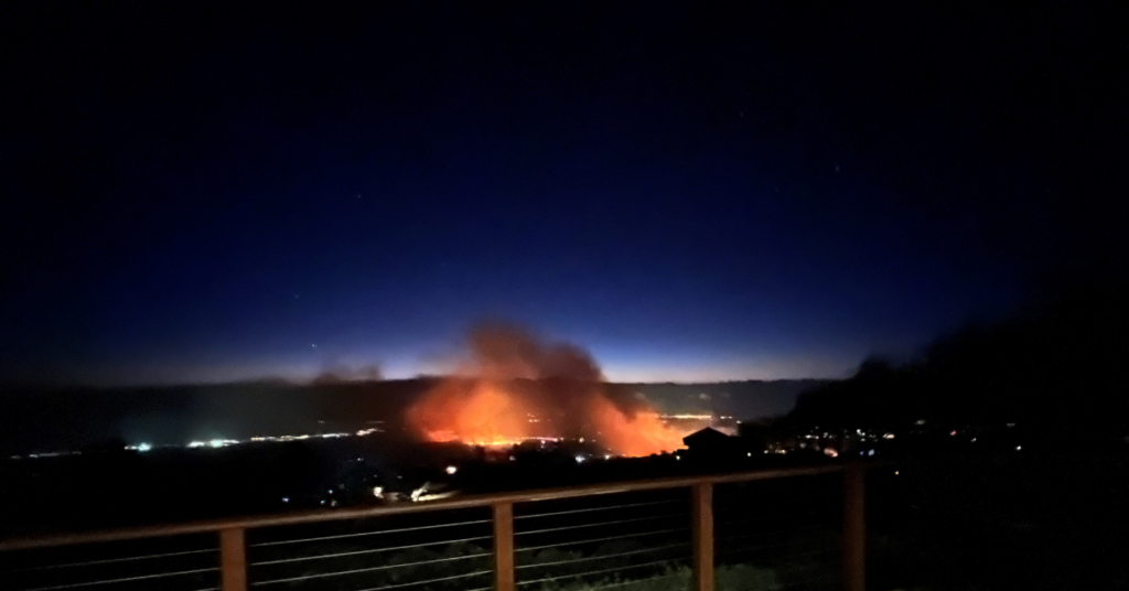 The glow from the fires is visible beyond Kula Elementary School in Maui. The school was in the vicinity of the upland fires but was not burned.