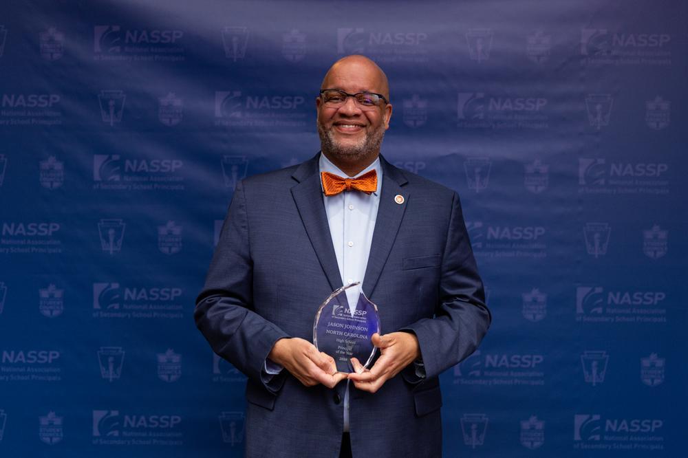 Jason Johnson stands with his award for the 2026 National High School Principal of the Year. Photo courtesy of NASSP.